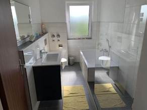 A bathroom with a sink and bathtub
AI-generated content may be incorrect.